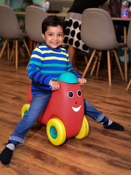 Cruising through the cafe area on one of our fun ride-on toys. It's a great way for toddlers to move around and explore.
