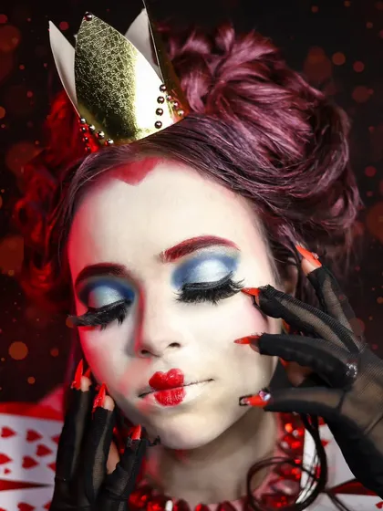A close-up of the Queen of Hearts makeup, featuring her signature heart-shaped lips, tiny eyebrows, and dramatic blue eyeshadow.