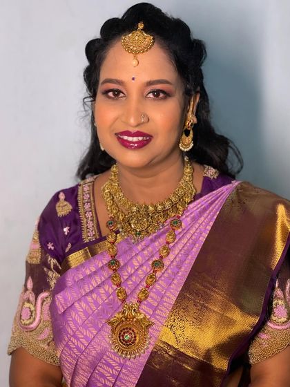 A smiling client with her beautiful curly hair styled for a special occasion.