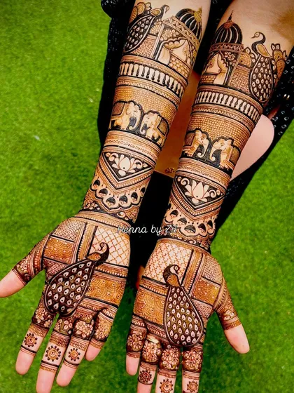 A beautiful example of symmetrical bridal mehendi. This design features elegant peacocks on the palms and rows of elephants marching up the arms, creating a cohesive and regal look.