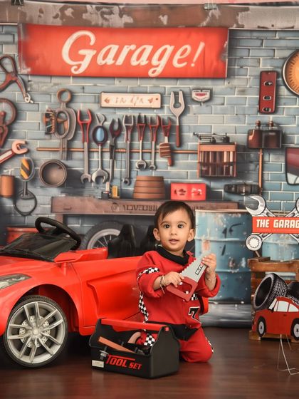 Getting his hands dirty in the garage. This car-themed shoot is full of fun props like a toy saw and toolset for your little mechanic to play with.