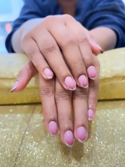 A clear, close-up view of the pink ombre and glitter manicure. You can really see the smooth transition of color and the sparkle of the glitter against the glossy finish.