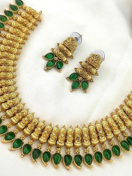 A simple and elegant antique necklace set in a beautiful shade of green. The matte gold finish and repeating motif design make it a very classy choice.