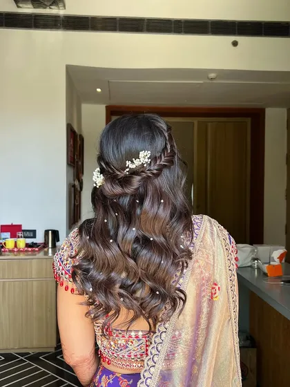 The pearl accessories add a touch of sophistication to the soft, romantic waves, creating a beautiful Haldi look.
