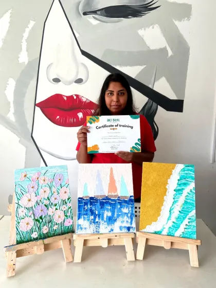 This student's vibrant artworks are the result of our texture and acrylic painting short-term course. She's proudly holding her certificate of completion.