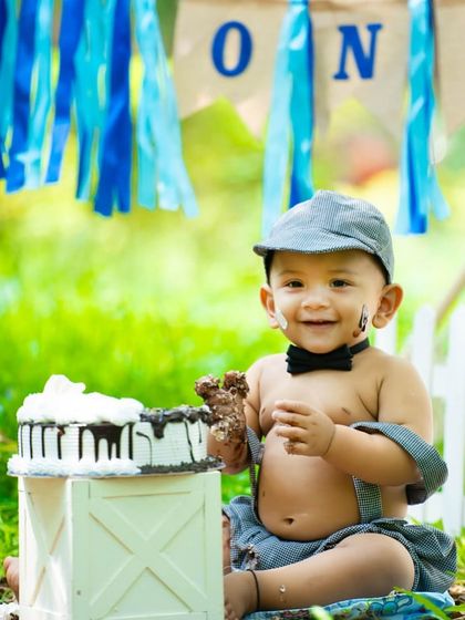 An outdoor cake smash is a fantastic option! This little boy is enjoying his cake in a sunny park, showing how we can take the celebration into nature.