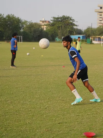 A senior player working on chest control during warm-ups.