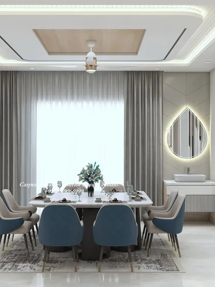 A beautiful dining room with blue chairs and a teardrop-shaped mirror. The wooden ceiling panel and soft curtains add warmth and texture to the space.