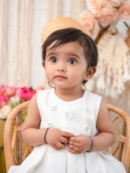 A curious gaze. This close-up shot in the boho chair highlights the baby's beautiful eyes and innocent expression.