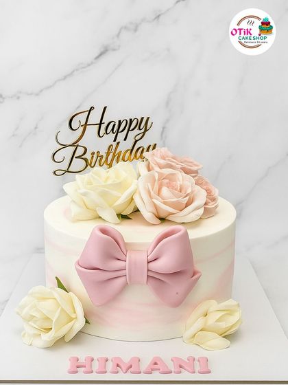 A soft and romantic design featuring a pink marble buttercream, a delicate pink fondant bow, and a cluster of beautiful cream and blush sugar roses. Perfect for a sweet and elegant birthday.