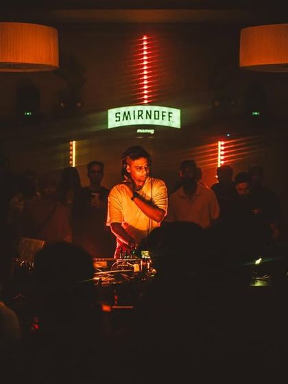 The Mixmag Lab event at our Park Ballroom was a phenomenal showcase of musical talent. Here, the DJ is framed by the iconic Smirnoff sign and atmospheric lighting.