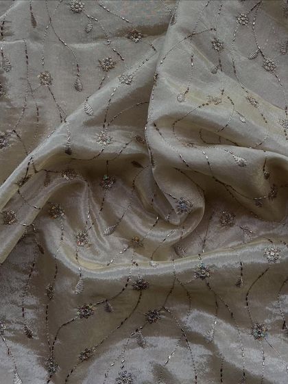 Tissue with a twist. This sheer fabric is layered with fine floral embroidery and sequins, giving it a subtle shimmer and a look of pure elegance.