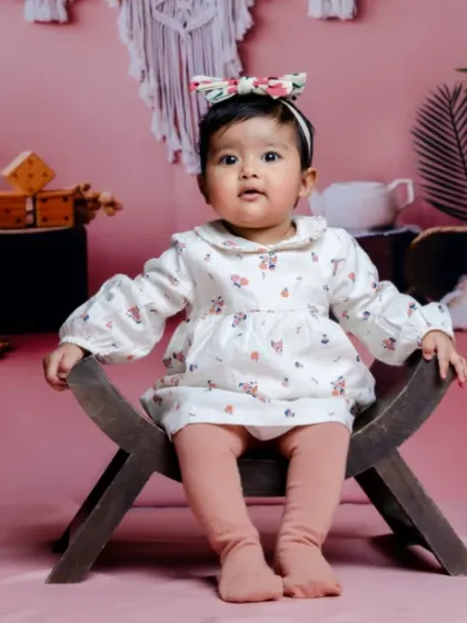 Swaddled with love, sprinkled with magic. A beautiful portrait against a soft pink backdrop.