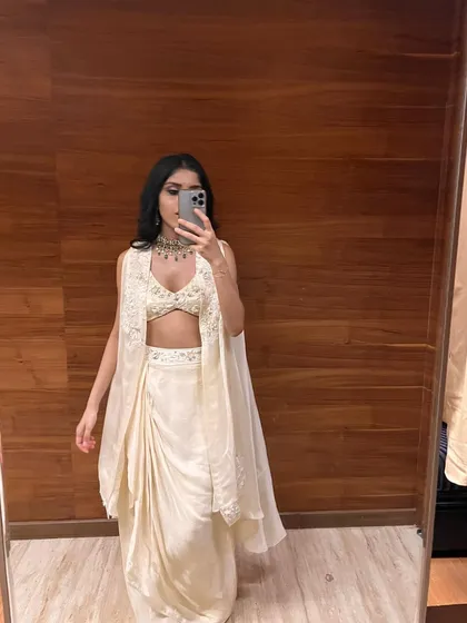 A happy client sharing a look at her custom-draped skirt and blouse set. This Indo-Western ensemble, with its elegant jacket and modern silhouette, shows how we can create the perfect party outfit that is both stylish and comfortable, even through remote consultations.