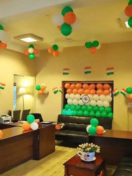 I can turn any office space into a festive environment. For this Independence Day office decor, I created a large Indian flag backdrop made entirely of balloons, which serves as a powerful focal point, complemented by balloon bunches on the ceiling to fill the room.