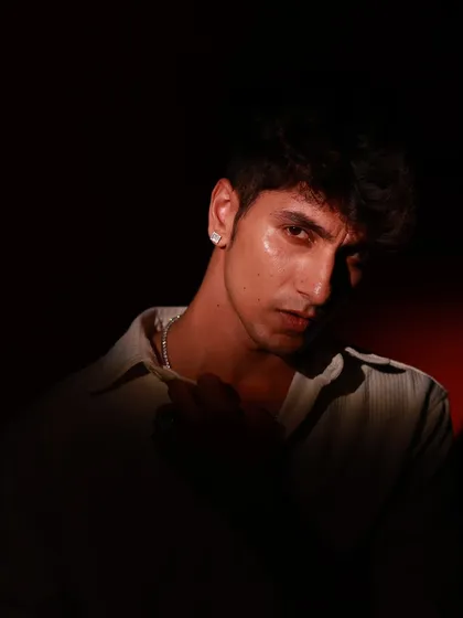 A close-up of the male model, focusing on his intense expression and the play of light and shadow.