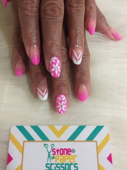 This pretty pink set combines a soft ombre effect with hand-painted white flowers. It's a feminine and classic design that works beautifully on shorter nails.