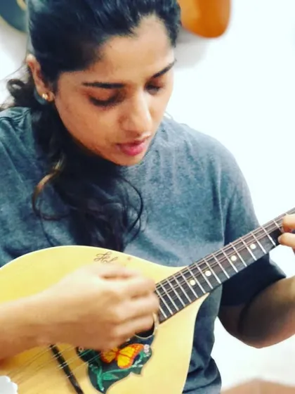 This student is focused on her picking technique for the mandolin. Its eight strings are tuned in pairs, which allows for techniques like the tremolo to create a sustained sound.