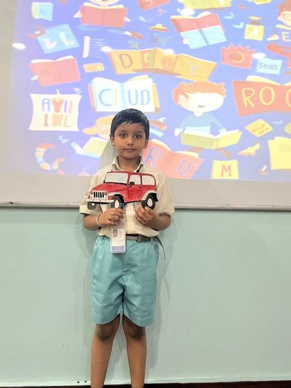 This student proudly holds up his creation for a vocabulary-building activity. We use tangible props and crafts to make learning new words a hands-on and memorable experience.
