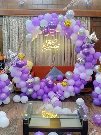 A fun and unique birthday theme for an adult, with whiskey and beer foil balloons and a purple and silver color scheme.