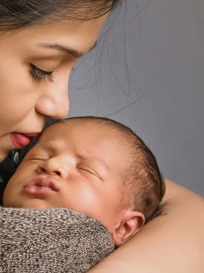 The quiet connection between a mother and her newborn is truly special. This close-up shot captures a tender kiss, highlighting the peacefulness and deep love of these first few days together.