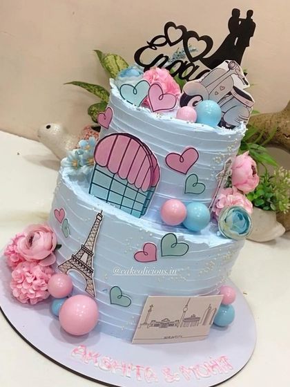 This thoughtful two-tier engagement cake tells the couple's story, depicting their journey of togetherness across Paris and Berlin. It's decorated with edible prints of the Eiffel Tower, hearts, and a scooter for a truly personal touch.