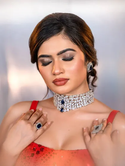 A close-up of the red gown look, focusing on the smokey eye makeup and contoured features.