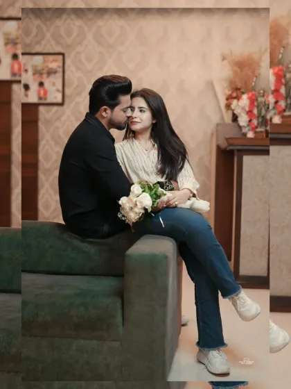 A sweet and romantic portrait of a couple on a sofa, with the bride holding a bouquet of white roses, capturing a moment of gentle affection.