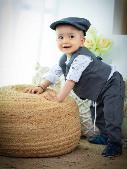 A dapper little gentleman trying to stand. The simple jute pouf is a great prop for babies who are just finding their feet.