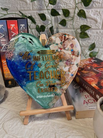 The teacher plaque displayed on an easel, surrounded by books. It's a tribute to the knowledge and inspiration that teachers provide.