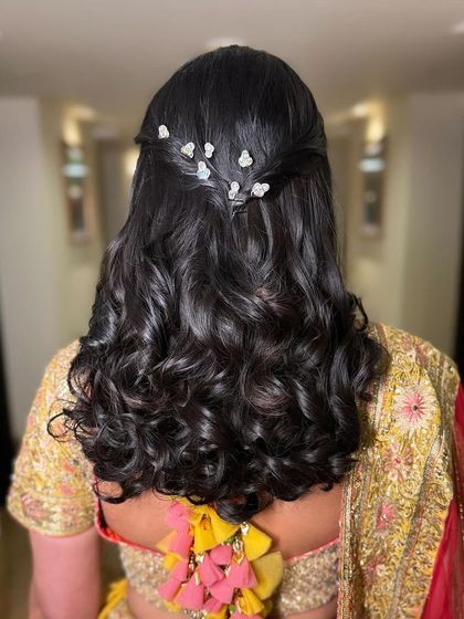 A back view of the half-up style with curls, showing its clean and polished finish.