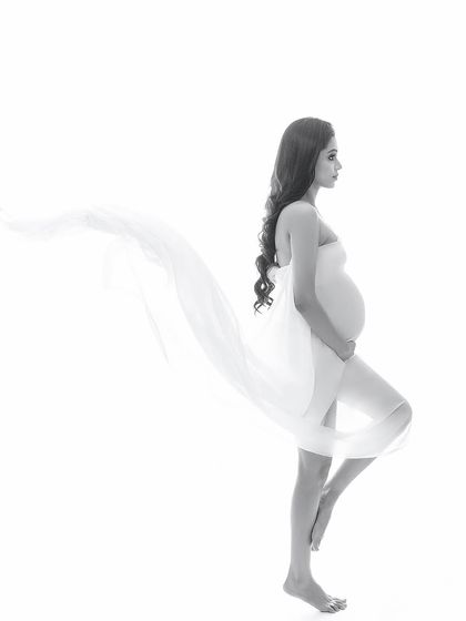 An artistic black and white silhouette against a pure white background. The flowing fabric creates a sense of weightlessness and grace, resulting in a minimalist yet impactful image.