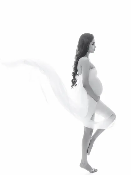 An artistic black and white silhouette against a pure white background. The flowing fabric creates a sense of weightlessness and grace, resulting in a minimalist yet impactful image.