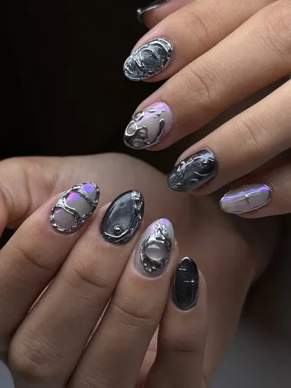 A full view of a futuristic 3D chrome manicure. Each nail has a unique, sculpted metallic design, creating a cohesive yet varied and artistic look.