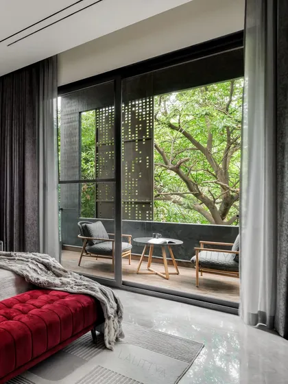 A bedroom should be a personal sanctuary. For this son's room, we blended muted tones with a bold red accent to create a space that is both cool and cozy. The private balcony, shielded by a perforated screen, connects the room to nature while maintaining privacy.
