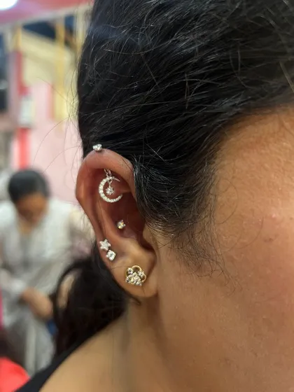 A celestial-themed ear stack with a crescent moon and star hanging, perfect for those who love a dreamy, whimsical style.