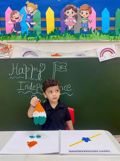 This little boy proudly displays his handmade tri-colour craft. Our art sessions are designed to build confidence and give children a sense of accomplishment.