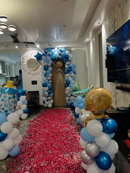 The stunning entrance with a balloon arch and a carpet of red rose petals to welcome the newborn.