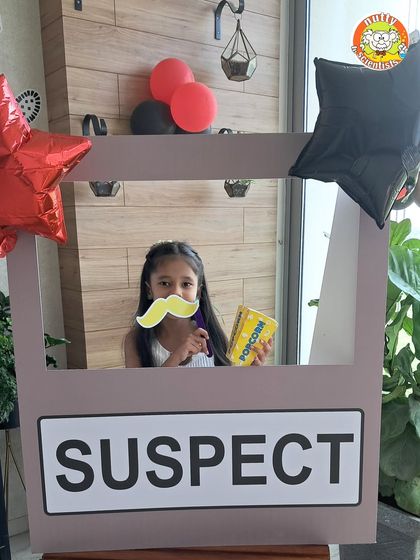 The investigation begins with our lineup of silly suspects. This photo booth prop is a fun way for kids to get into character, posing with detective props like mustaches and popcorn evidence.