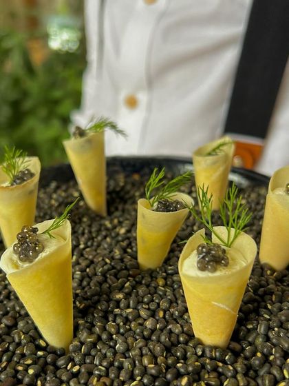 Caviar and cream cheese served in a delicate cone, an elegant and creative one-bite canapé.
