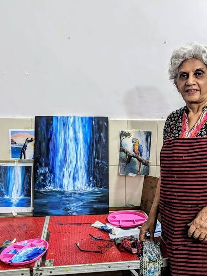 Harinder ma'am standing proudly next to her completed waterfall painting. Her passion for art shines through in every piece she creates.