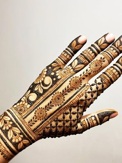 The back of the hand for a full coverage design, showing a mix of patterns including a floral vine strip and a moon motif.