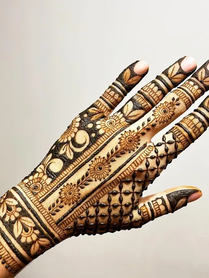 The back of the hand for a full coverage design, showing a mix of patterns including a floral vine strip and a moon motif.