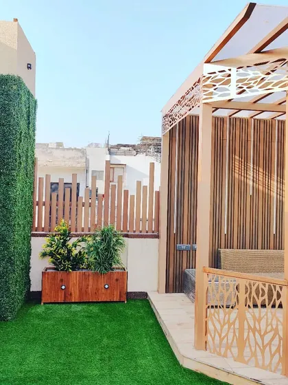 This view shows the combination of the pergola, a vertical garden wall, and a wooden planter, creating a layered and green environment.