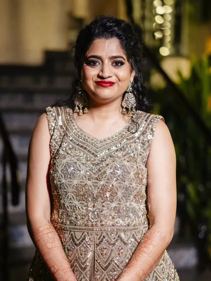 A series of photos from a Sangeet night in Goa. This look features a classic combination of smokey eyes and red lips, paired with a side-swept curly hairstyle, creating a glamorous and festive vibe.