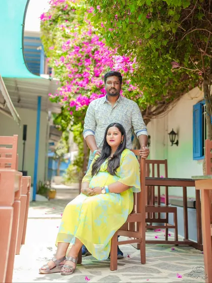 A relaxed portrait of a couple in a charming, European-style cafe setting.