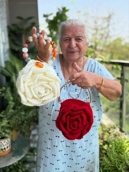 Dadi holding our white and red Rose bags. The beaded handle on the white one adds a unique, colorful touch.