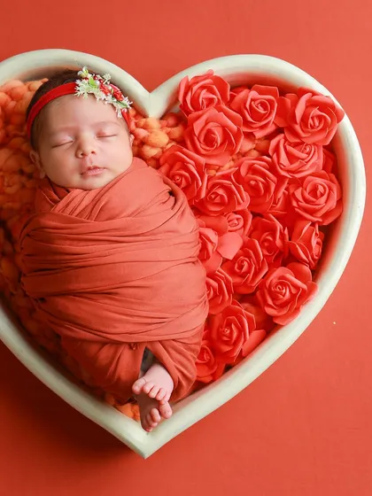 A peacefully sleeping baby, nestled amongst soft roses. This is the heart of my classic newborn sessions. I use simple, beautiful props like this heart-shaped basket to create a timeless portrait where your baby's innocence is the true centerpiece.
