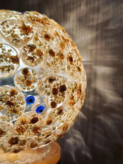 A detailed shot of the globe lamp, showing how the preserved flower pieces create a beautiful mosaic effect when lit up.