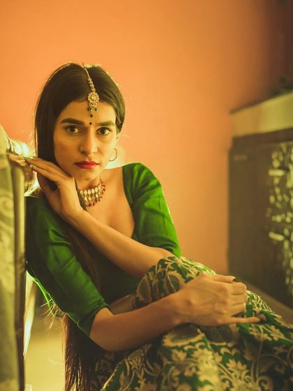 A portrait that plays with pose and expression. The model's pose, leaning against the furniture, combined with her direct look, creates a feeling of relaxed confidence in this editorial shot.